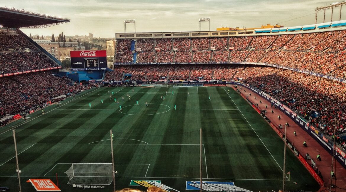 green soccer field with crowd at daytime